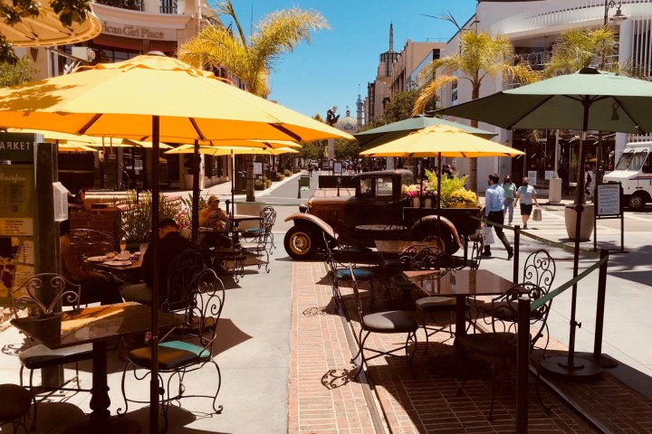 a group of people sitting at a table with an umbrella
